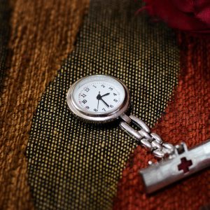 Silver pocket watch with a chunky short silver chain.
