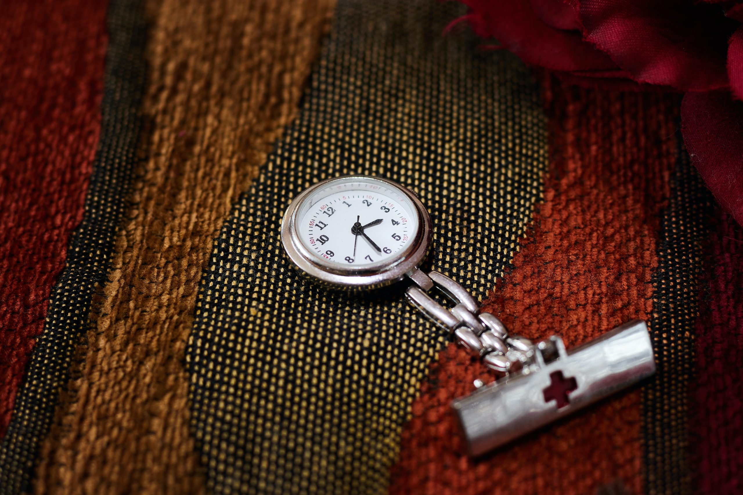 Gold pocket watch with a button hole peg on the end of the chain for fastening to a jacket or pants.