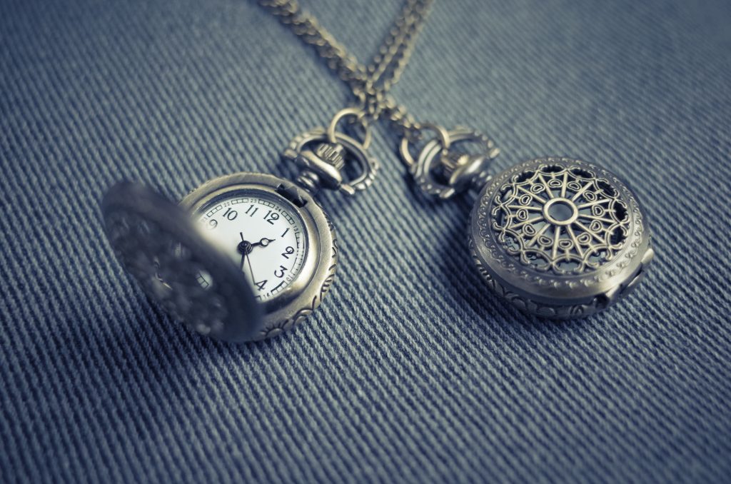 Silver antique pocket watch duo on a silver chain.
