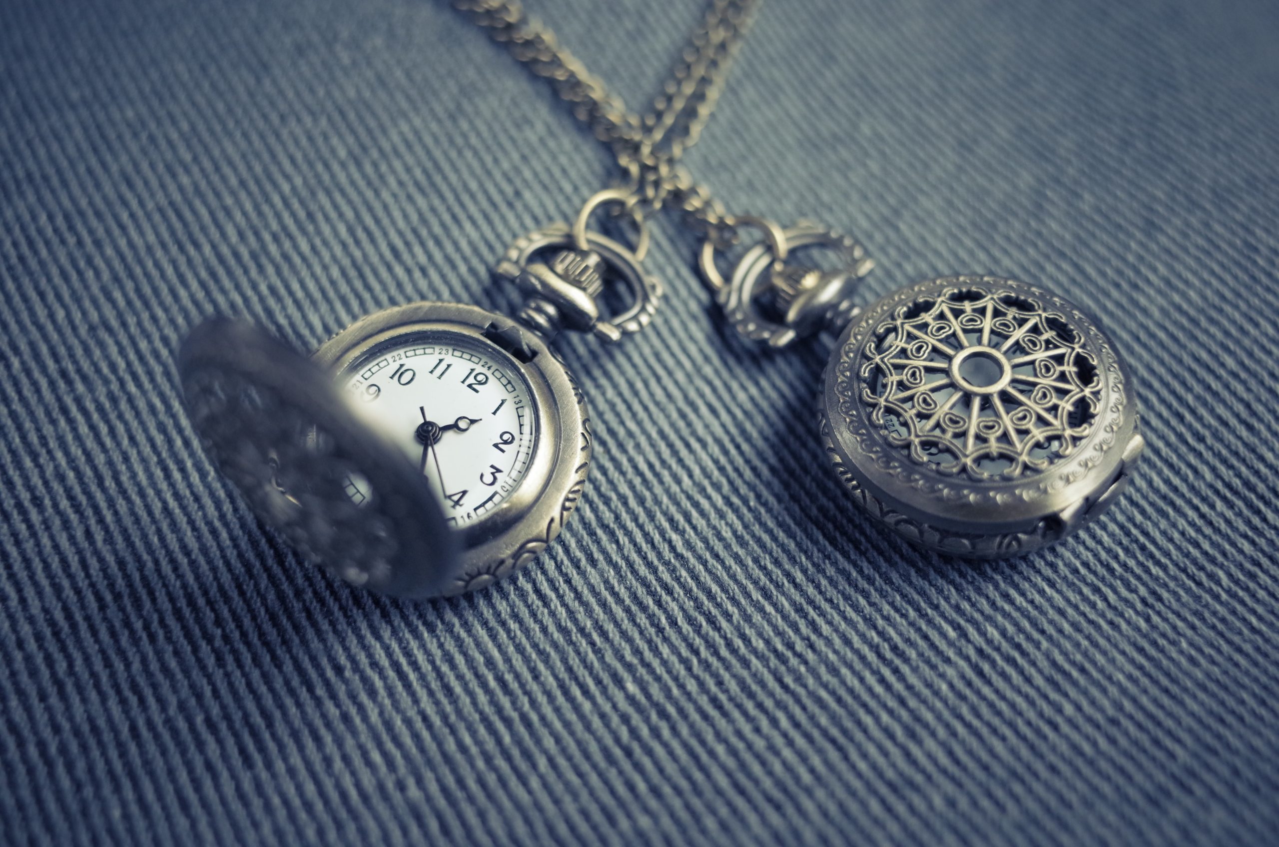 Gold pocket watch with a button hole peg on the end of the chain for fastening to a jacket or pants.