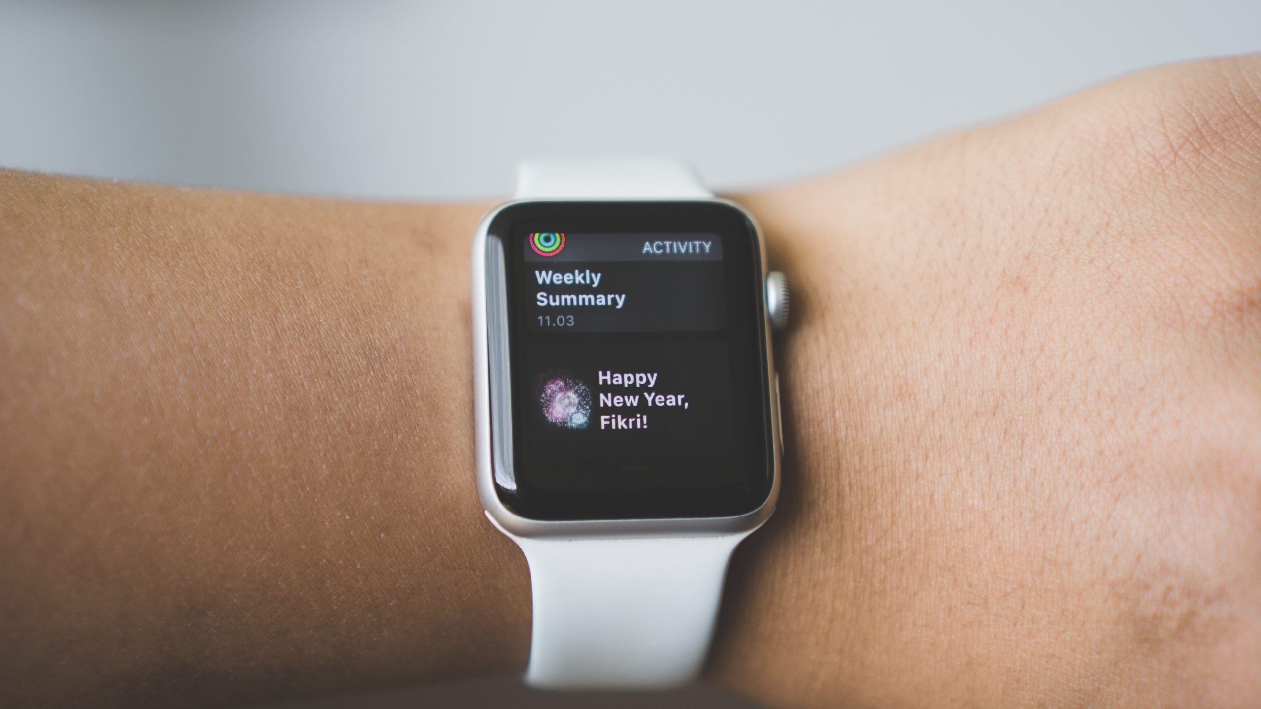Black cased smart watch with a black band on an arm wearing a black coat in the winter time.