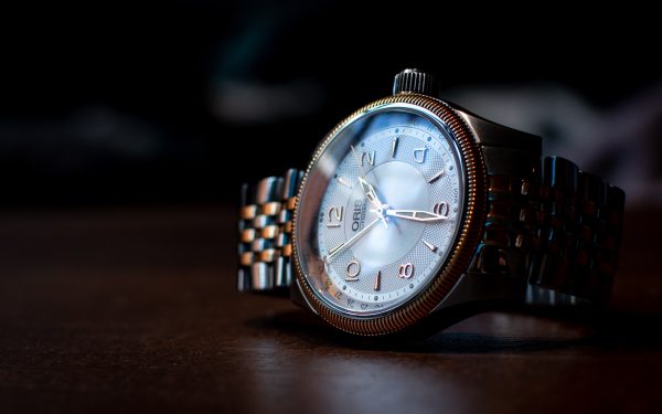 Gold and silver toned watch with a pearl dial and gold numbers by ORIS
