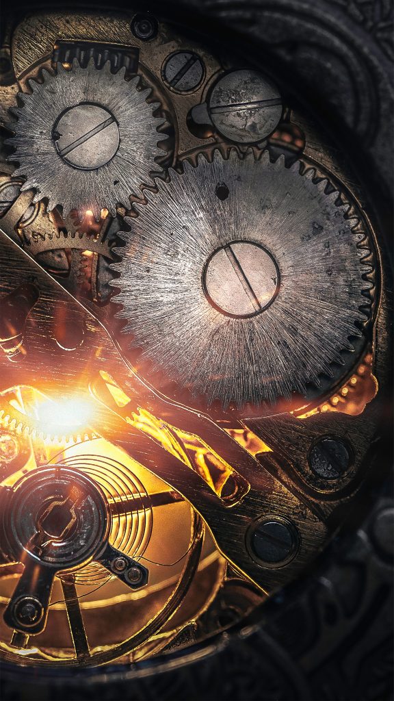 Inner workings of a clock magnified in a industrial and steampunk settings with a bright golden light shining through the gears.